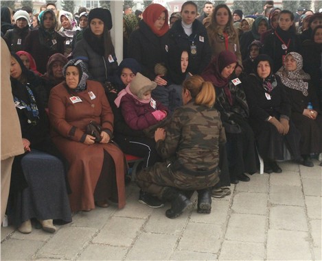 Üşüyen şehit kızına bayan özel harekat polisi montunu giydirdi